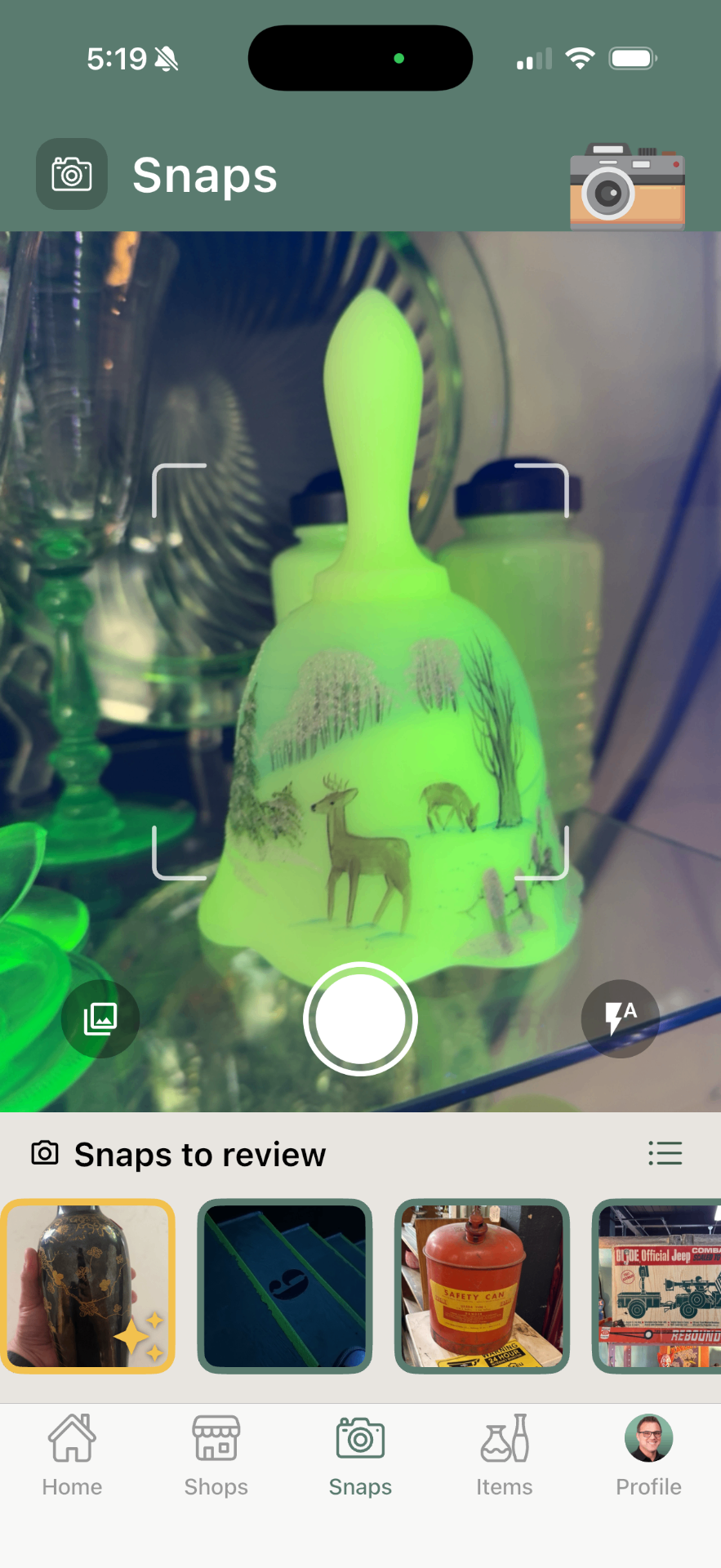 Trésora Snaps screen — camera viewfinder capturing a vintage uranium glass bell, with a Snaps to review tray